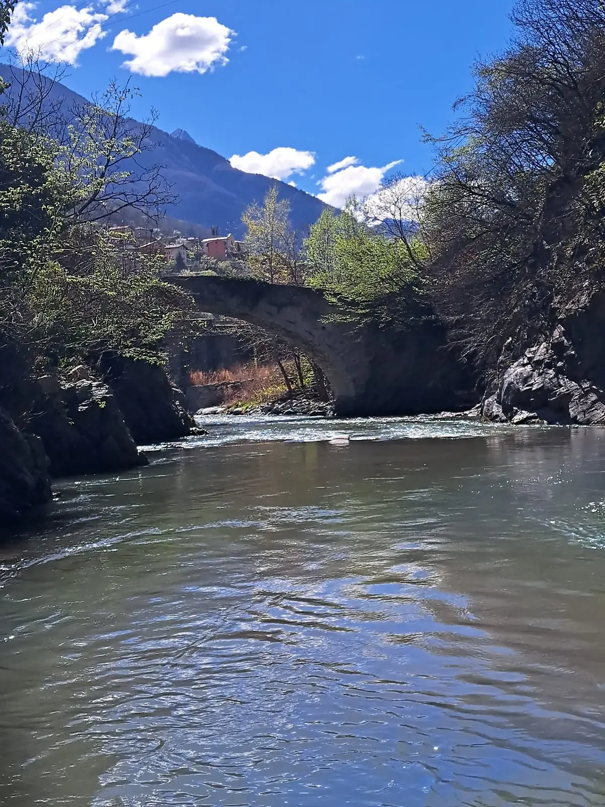 Il fiume Oglio sotto un ponte in pietra in Valle Camonica